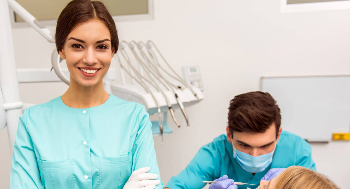 a woman dressed like a dentist assistant smiling